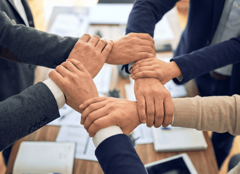 situational leadership teamwork 多位團隊成員以手臂相互支撐,象徵依不同情境調整領導與合作方式。